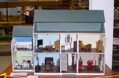 [Two story eight room dollhouse completely open on one side.]